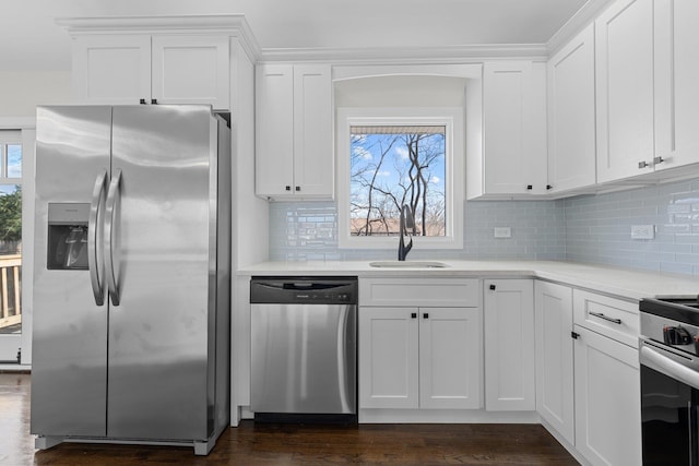 kitchen featuring sink, dark hardwood / wood-style flooring, backsplash, white cabinets, and appliances with stainless steel finishes