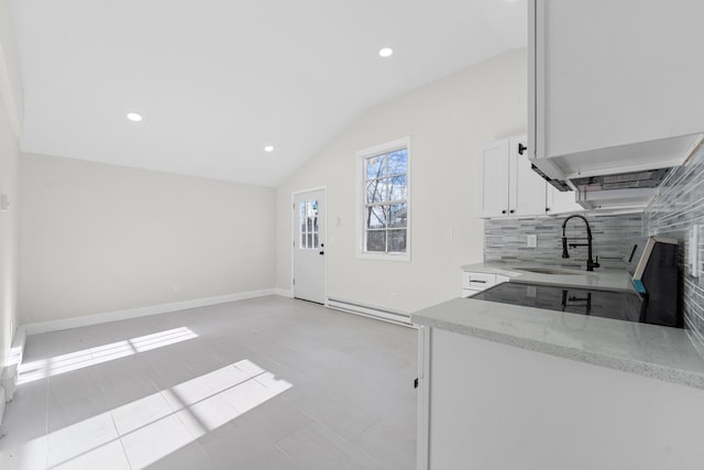 kitchen featuring light stone countertops, sink, light tile patterned floors, white cabinets, and lofted ceiling