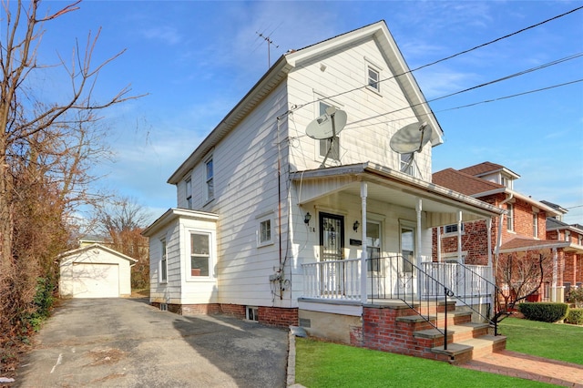 view of front of house with a front yard, a porch, a garage, and an outdoor structure