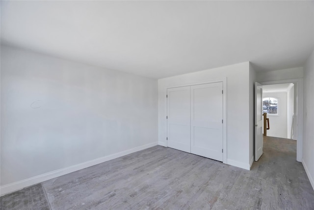 unfurnished bedroom featuring light hardwood / wood-style floors and a closet