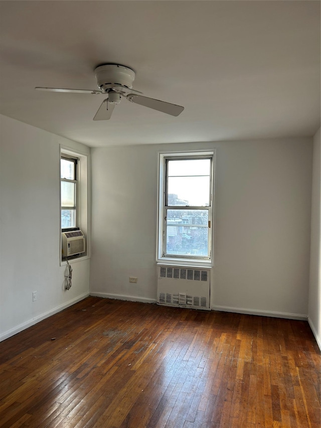 spare room featuring radiator, a wealth of natural light, and dark hardwood / wood-style floors