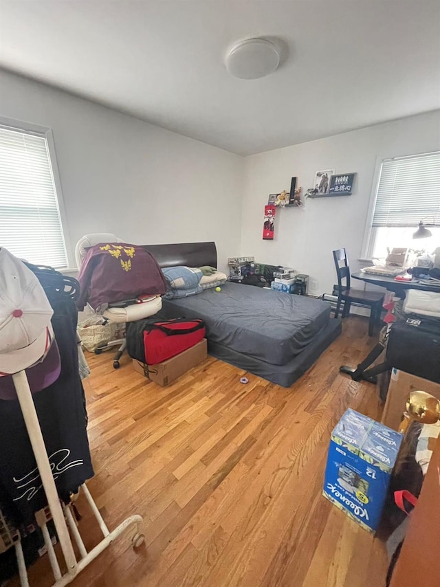 bedroom with hardwood / wood-style flooring and multiple windows