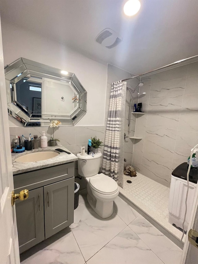 bathroom with vanity, toilet, walk in shower, and tile walls