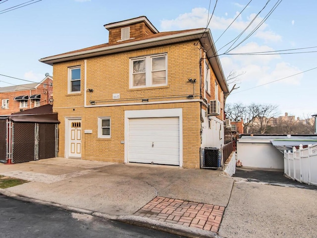 rear view of house featuring a garage and central air condition unit