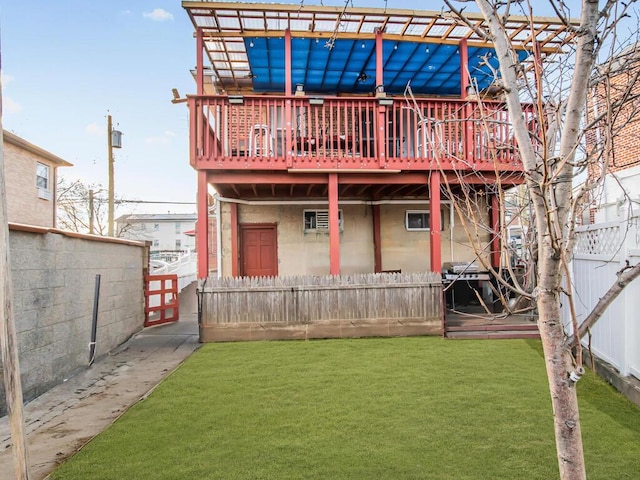 back of house with a wooden deck and a lawn