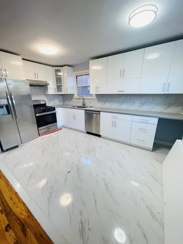 kitchen featuring decorative backsplash, sink, white cabinets, and stainless steel appliances