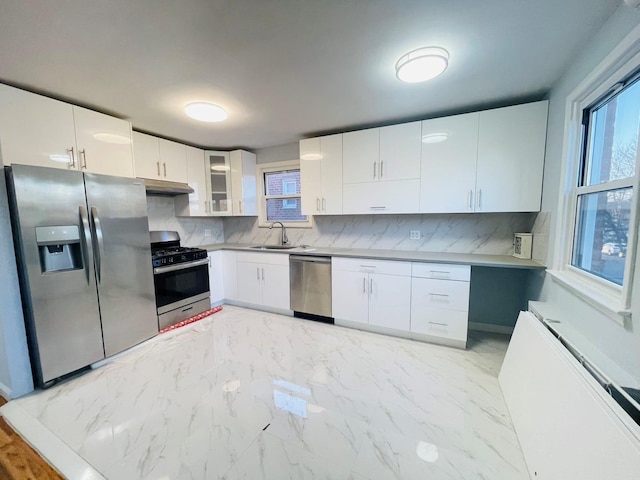 kitchen featuring white cabinets, appliances with stainless steel finishes, decorative backsplash, and sink