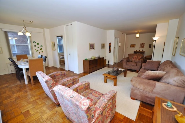 living room featuring an inviting chandelier and parquet flooring