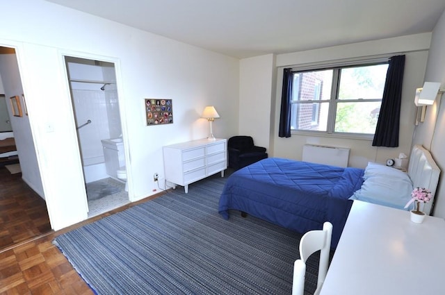 bedroom with connected bathroom and dark parquet flooring