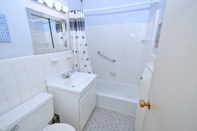 full bathroom with shower / tub combo with curtain, toilet, tile walls, vanity, and tile patterned flooring