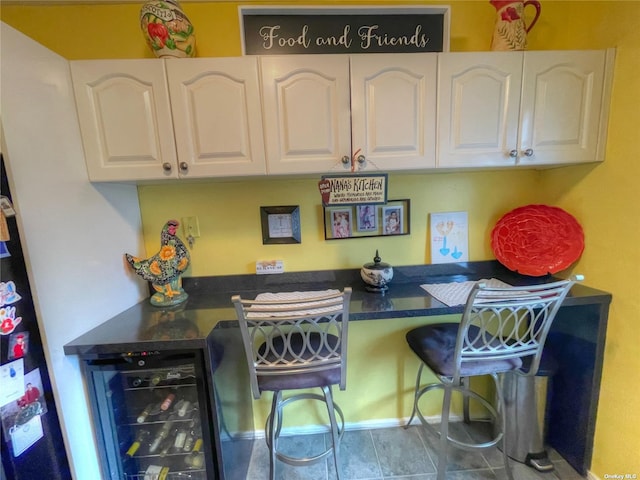 bar with white cabinetry and wine cooler