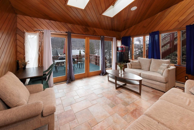 living room featuring wood walls, lofted ceiling with skylight, wood ceiling, and a baseboard heating unit