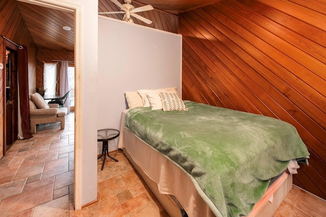 bedroom with ceiling fan, wood ceiling, and wood walls