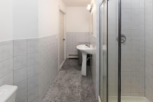 bathroom featuring toilet, tile walls, a baseboard radiator, and walk in shower