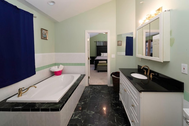 bathroom with a relaxing tiled tub, lofted ceiling, and vanity