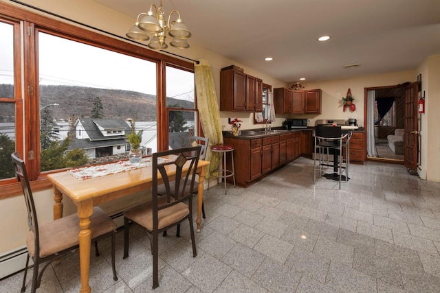 kitchen with a chandelier, pendant lighting, a baseboard radiator, and sink