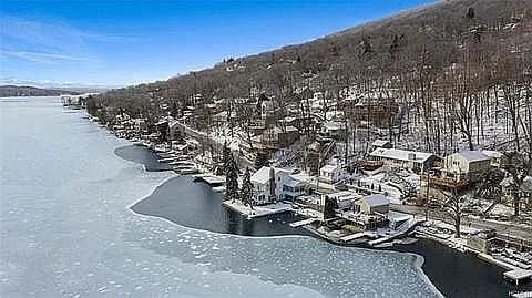 snowy aerial view featuring a water view