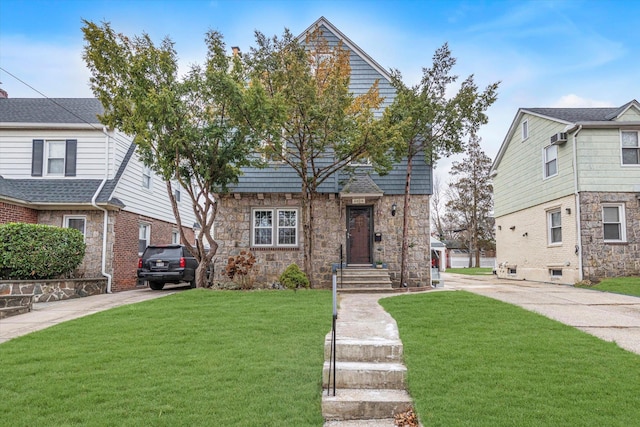 view of front of home with stone siding, a front lawn, and concrete driveway