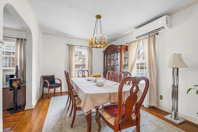 dining room featuring hardwood / wood-style floors, an AC wall unit, and crown molding