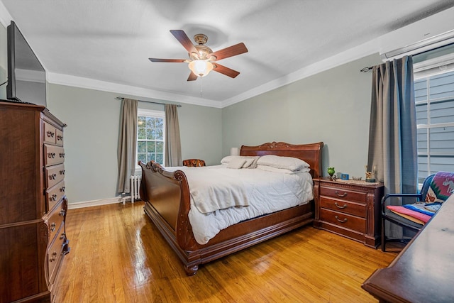 bedroom featuring ceiling fan, radiator heating unit, ornamental molding, and light wood-type flooring