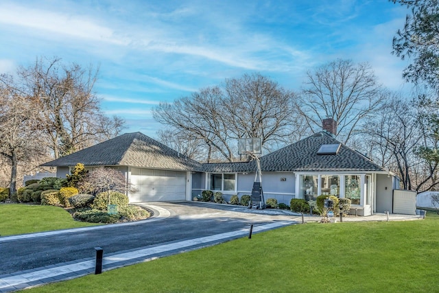 ranch-style home with a front lawn and a garage