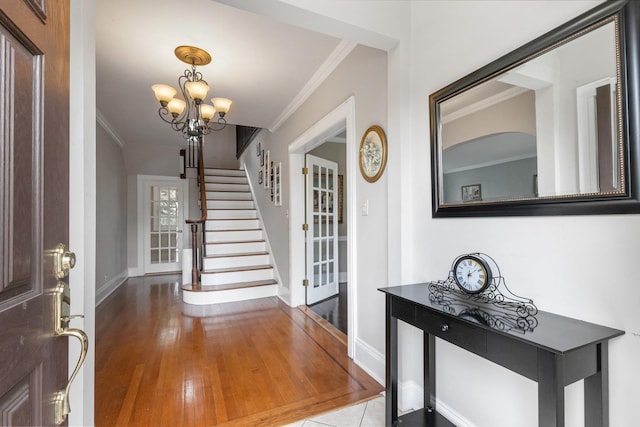 foyer entrance featuring an inviting chandelier and crown molding