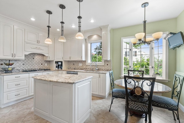 kitchen featuring white cabinetry, a center island, gas cooktop, and decorative light fixtures