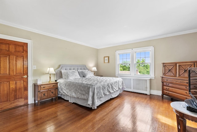 bedroom with hardwood / wood-style flooring, radiator heating unit, and ornamental molding