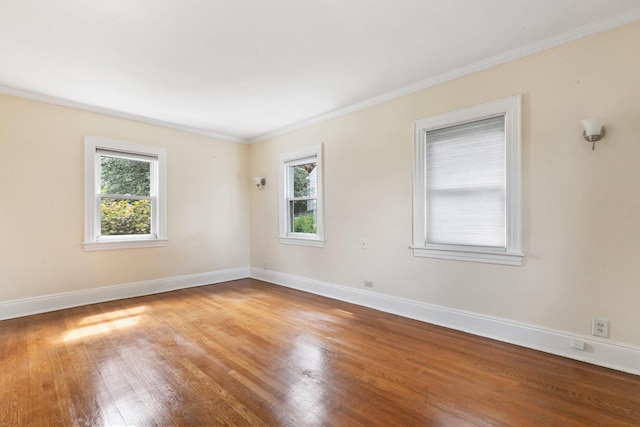 unfurnished room with crown molding, a healthy amount of sunlight, and light hardwood / wood-style floors