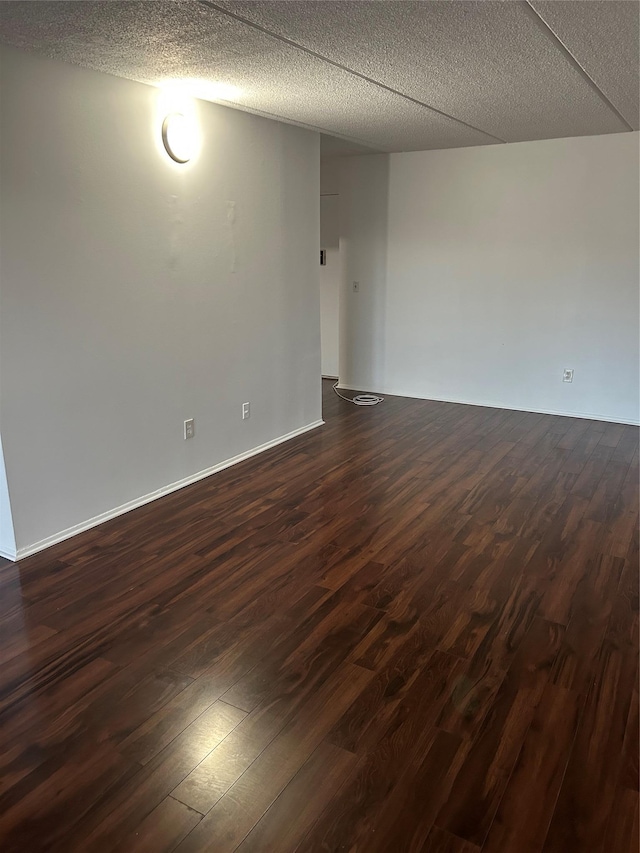 spare room with dark wood-type flooring and a textured ceiling