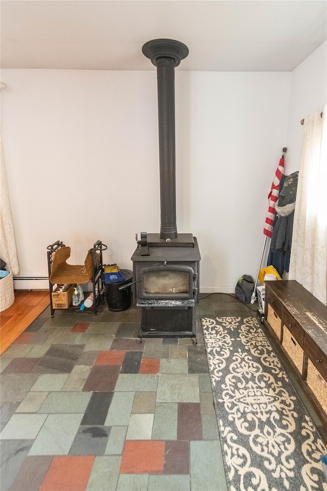 details featuring a wood stove and a baseboard heating unit