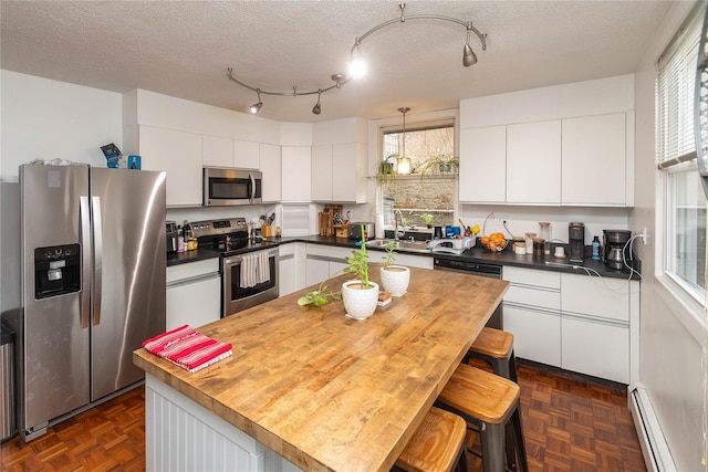 kitchen featuring white cabinets, a kitchen island, stainless steel appliances, and a baseboard radiator