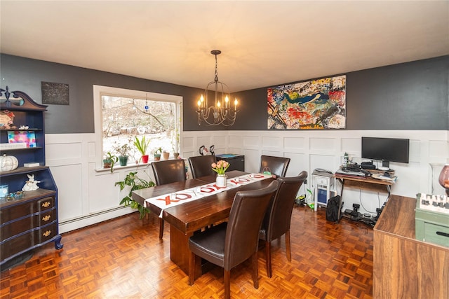 dining area with a baseboard heating unit, a notable chandelier, and dark parquet flooring