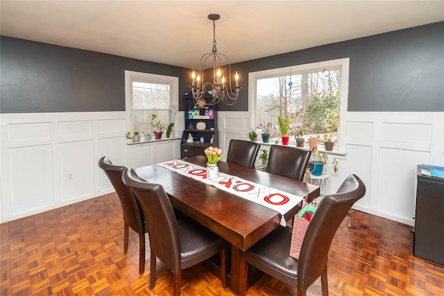 dining room featuring dark parquet flooring and a chandelier