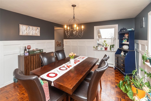 dining area featuring dark parquet floors and a notable chandelier