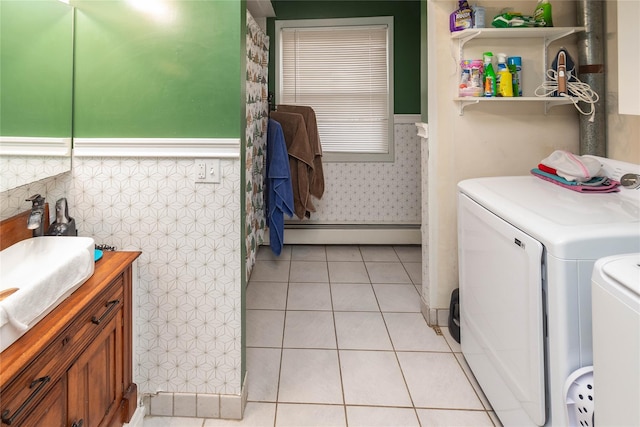 laundry room with washer and clothes dryer, light tile patterned floors, and a baseboard radiator