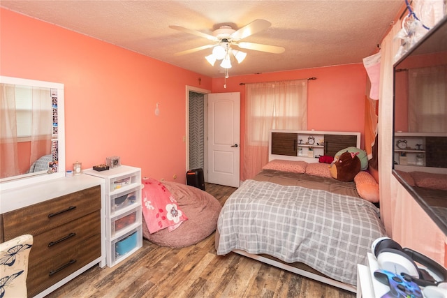 bedroom featuring ceiling fan, a textured ceiling, and hardwood / wood-style flooring