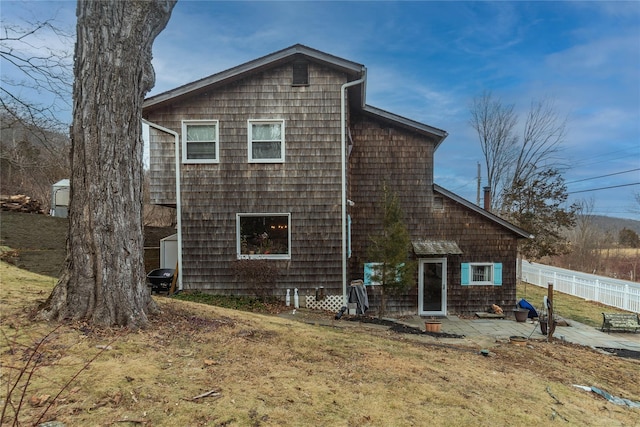 rear view of property featuring a patio area and a yard