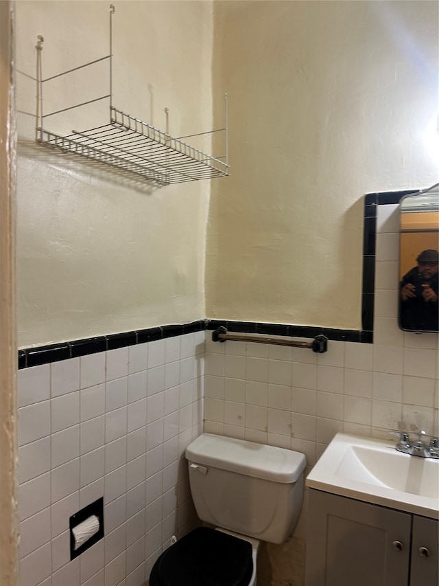 bathroom with a wainscoted wall, vanity, and toilet