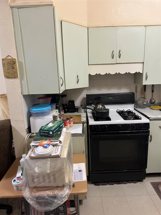 kitchen featuring light countertops, tasteful backsplash, and gas range