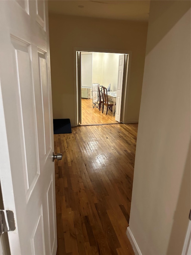 hallway featuring radiator and hardwood / wood-style floors