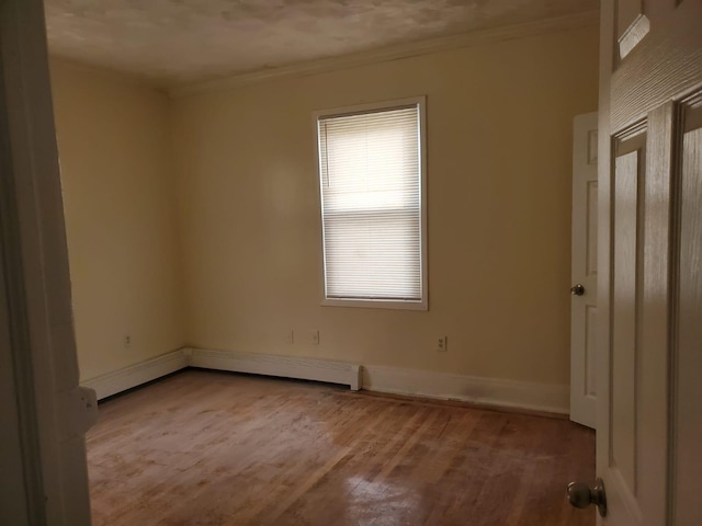 spare room featuring ornamental molding and light hardwood / wood-style flooring