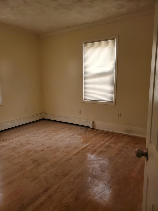 unfurnished room with baseboard heating and wood-type flooring