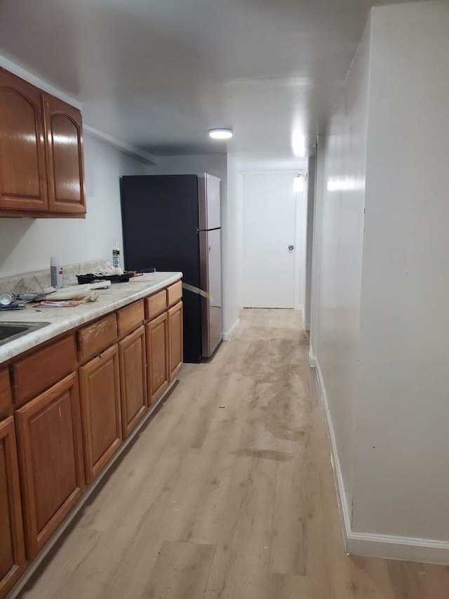 kitchen featuring stainless steel fridge and light hardwood / wood-style flooring