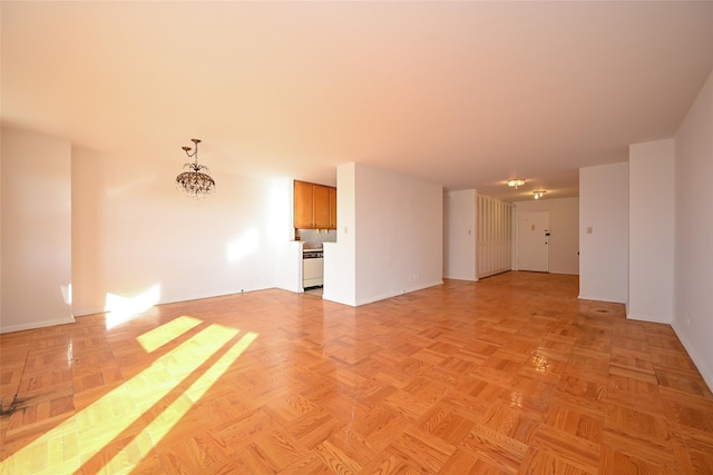 unfurnished room featuring light parquet floors and a notable chandelier