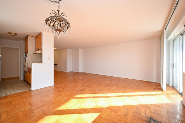 unfurnished living room featuring light parquet floors and a notable chandelier