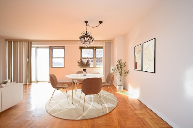 dining room with light parquet flooring and an inviting chandelier