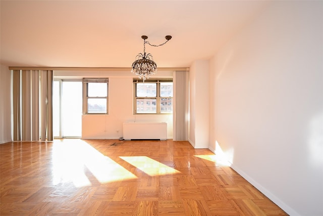 unfurnished room with light parquet flooring and an inviting chandelier