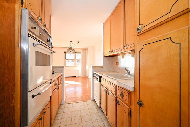 kitchen with dishwasher, sink, hanging light fixtures, tasteful backsplash, and wall oven