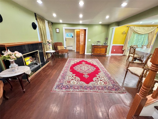 sitting room with radiator, dark hardwood / wood-style flooring, and a high end fireplace